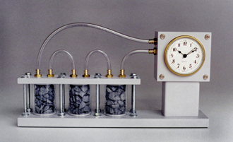 A clock with tubes connecting three recepticles holding stones